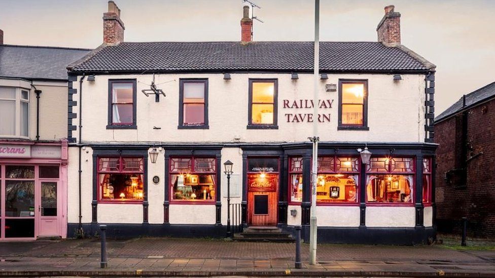 An old pub looking inviting with lights on in the windows