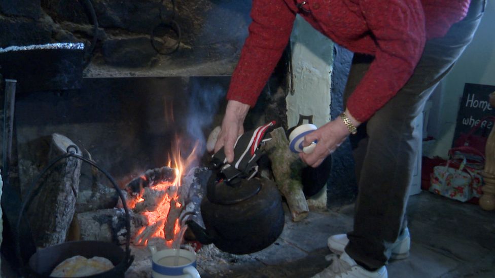 Margaret Gallagher cooks over an open fire