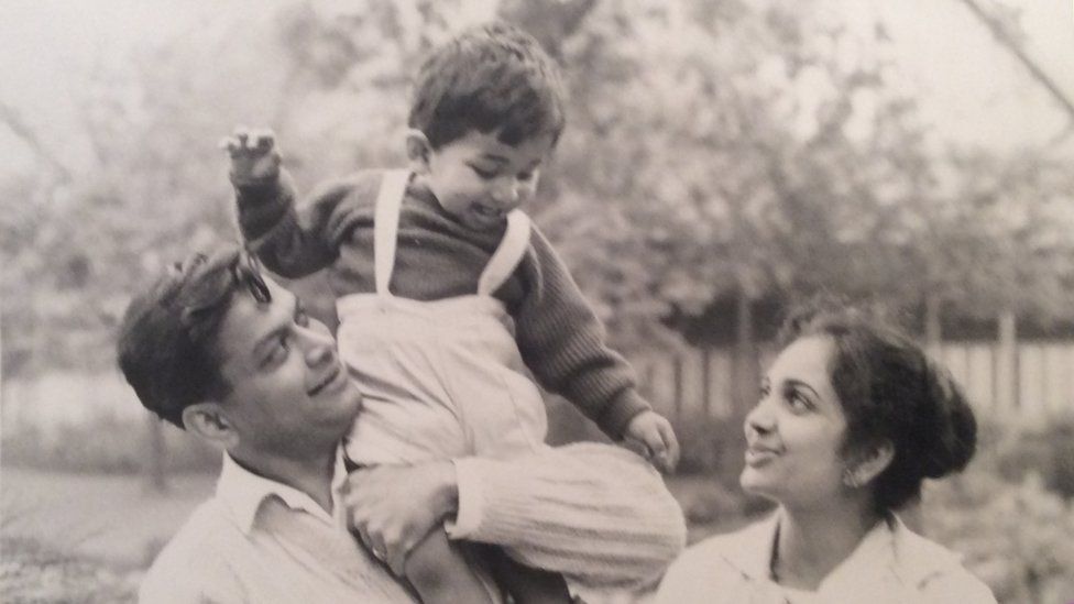 Rajan as a young boy being held by his father