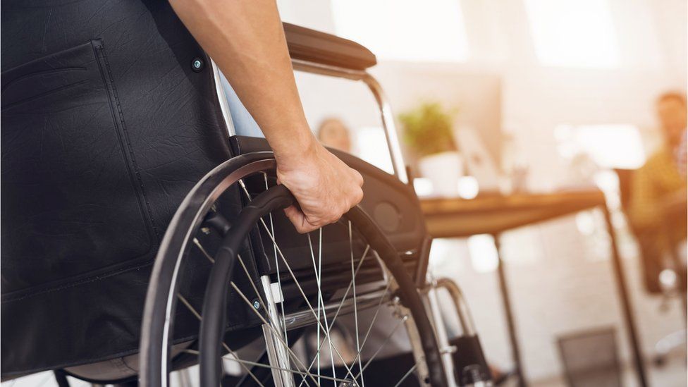 A man in a wheelchair working in an office