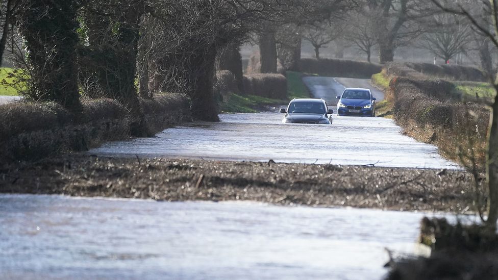Cars driving through flood water in Warwick bridge in Cumbria