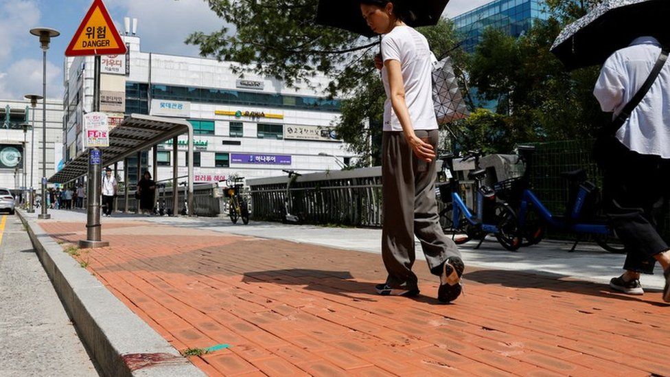 A woman walks past the scene where a random stabbing attack occurred, in front of a department store in Seongnam