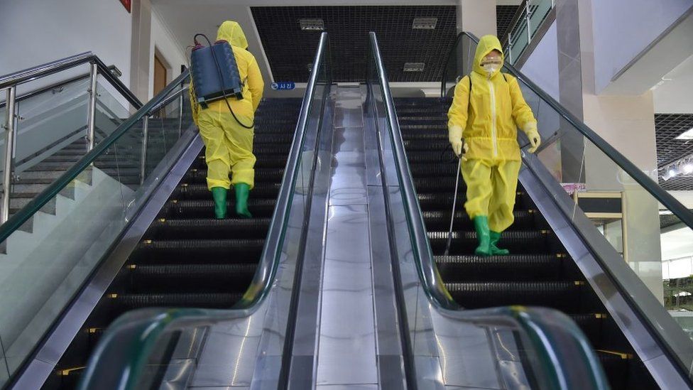 Employees spray disinfectant as part of preventative measures against Covid-19 in Pyongyang