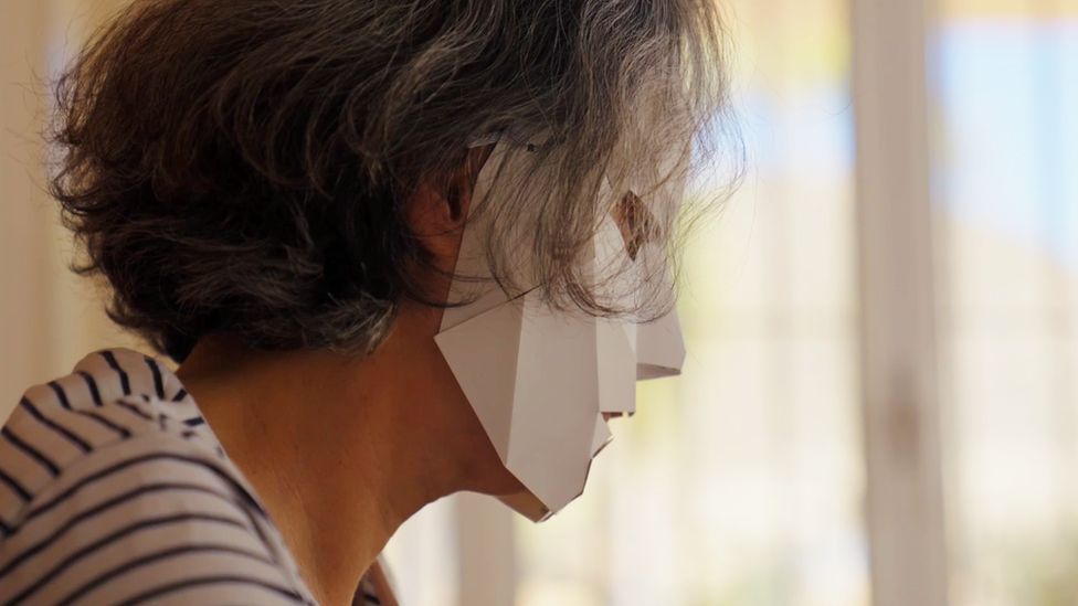 Мария, одна из ниндзя, сидит за своим столом в бумажной маске