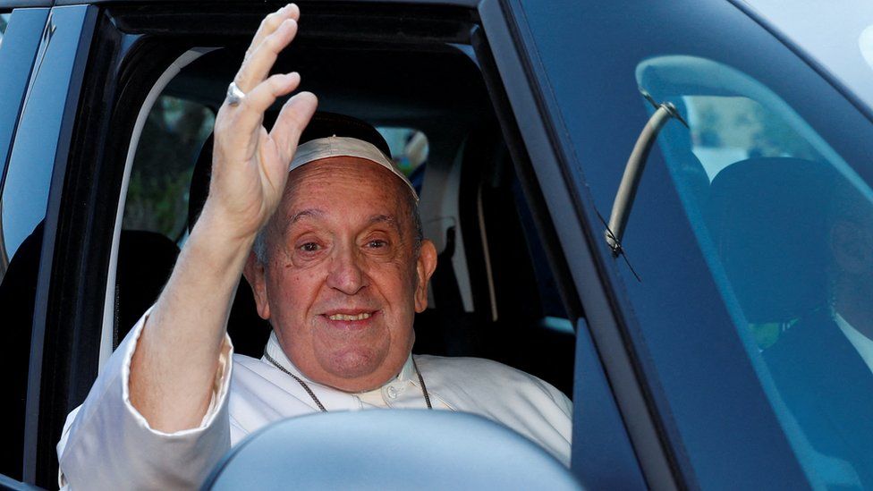 Pope Francis waves and smiles from a car having been discharged from Gemelli hospital in Rome, Italy