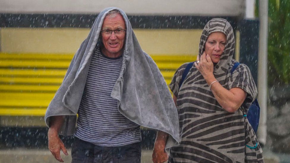 Two people shelter from rain in Falmouth