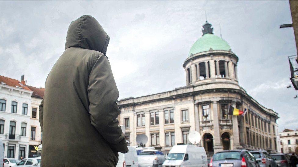 Мужчина идет по городской площади Моленбек, муниципалитет Брюсселя, Бельгия, 17 ноября 2015 г.