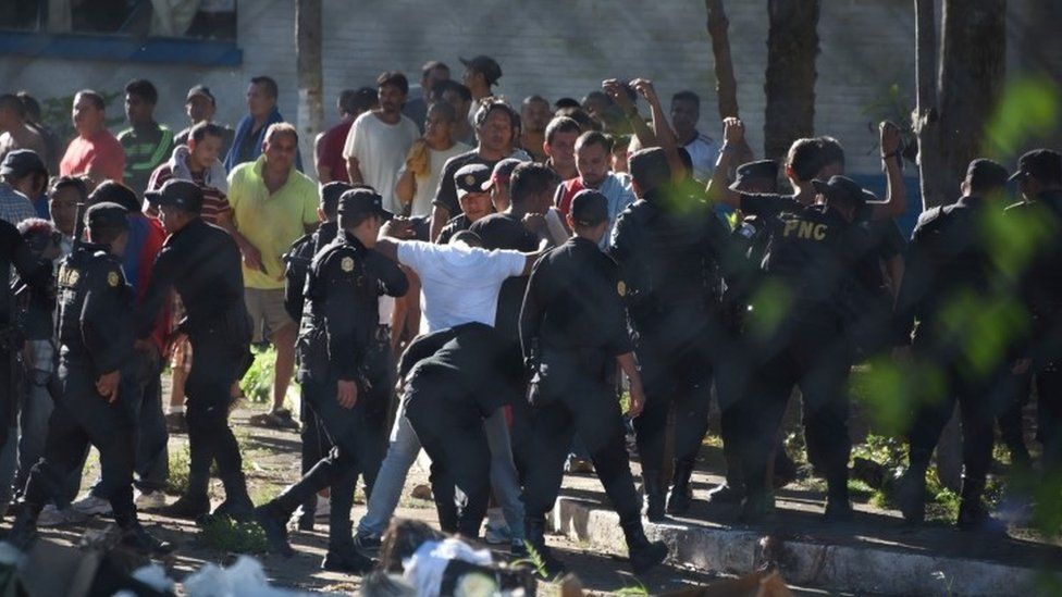 Guatemalan anti-riot policem guard a group of inmates after regaining the control of Canada maximum security prison in Escuintla department, 75 km south of Guatemala City on November 30, 2015.