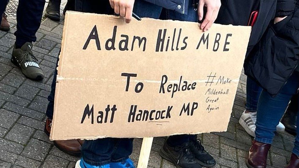 Placard which reads: Adam Hills MBE to replace Matt Hancock MP #make Mildenhall Great Again