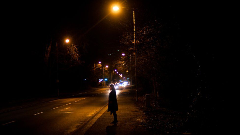 Woman under a street lamp