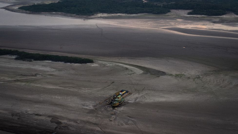 Aerial view of raft with vehicles, gas and supplies gets stuck in the dry bed of the Rio Negro on October 3, 2023 in Manaus, Brazil.