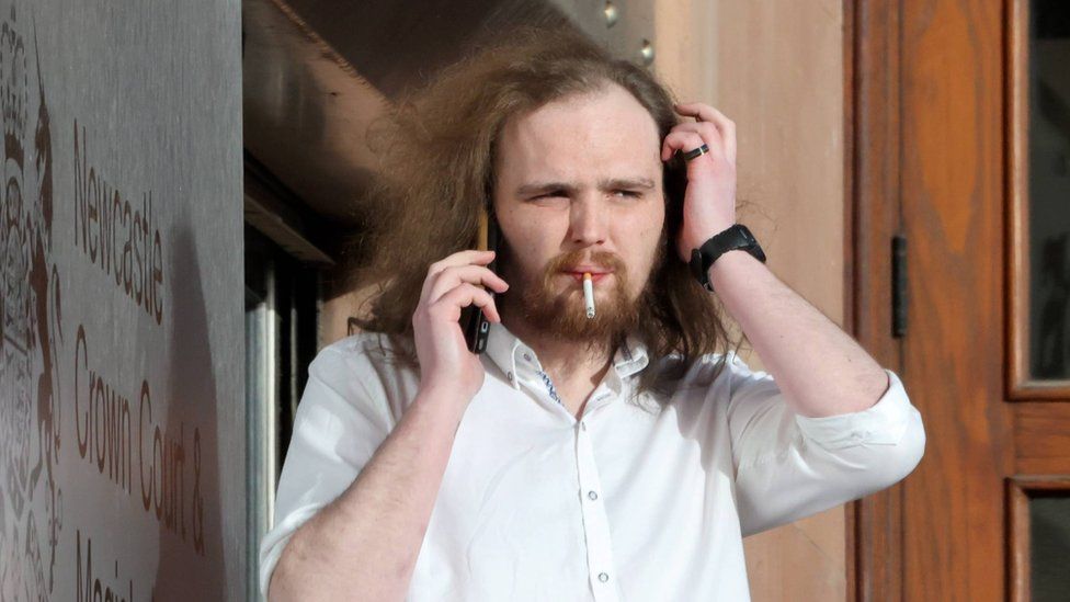 Liam Smith smokes a cigarette outside a court