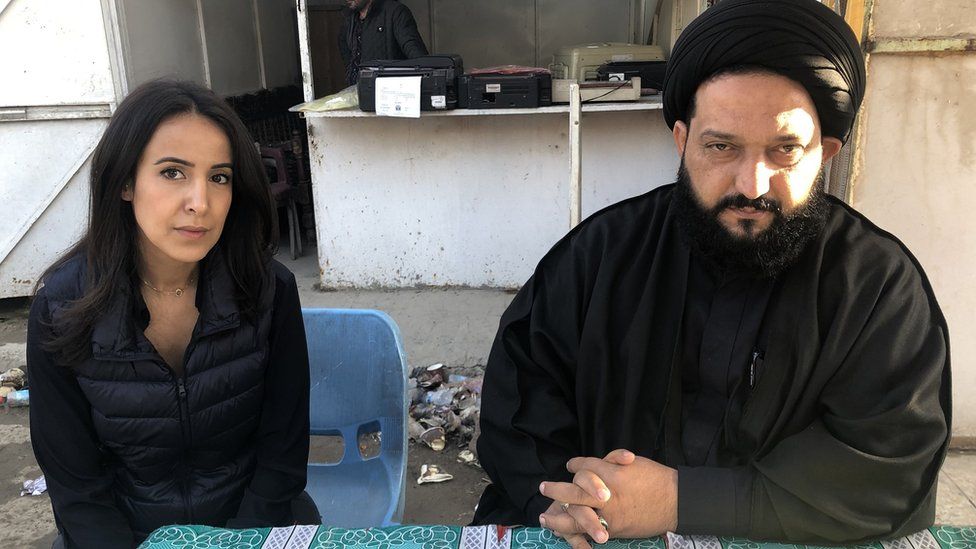 The BBC's Nawal al_Maghafi with a cleric outside Sadr City court