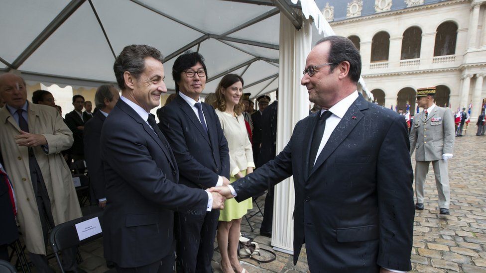 Francois Hollande, right, shakes hands with former French President Nicolas Sarkozy, 25 September 2016