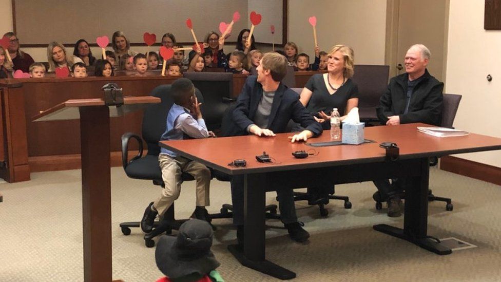 A picture shared by Kent County, Michigan's Facebook page shows a little boy named Michael being formally adopted in court, watched by his Kindergarten classmates