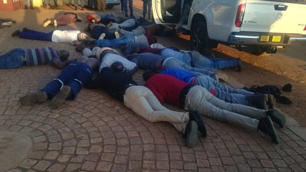 A picture of suspects being made to lie down after the attack