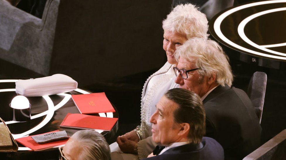 HOLLYWOOD, CALIFORNIA - MARCH 27: (L-R) Hélène Patarot, Ciarán Hinds, and Judi Dench attend the 94th Annual Academy Awards at Dolby Theatre on March 27, 2022 in Hollywood, California. (Photo by Neilson Barnard/Getty Images)