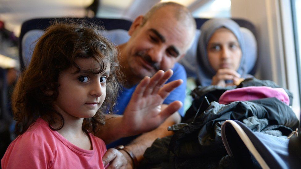 A migrant family from Syria sits in a special train at the train station in Munich, southern Germany, on September 13, 2015.