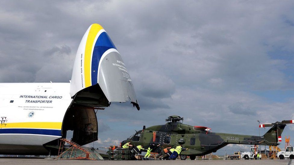 A German helicopter is loaded onto a plane as it returns from Afghanistan