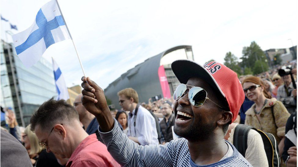 Participant of a demonstration called "We have a Dream - Multiculturalism is not a nightmare" waves a Finnish flag in Helsinki, Finland, on July 28, 2015