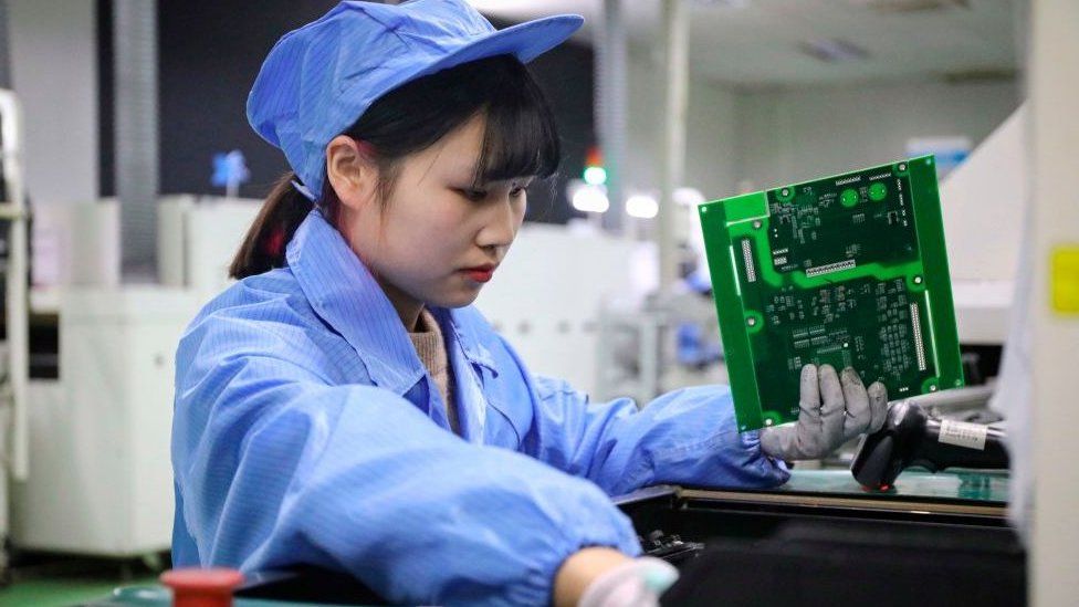 This photo taken on December 23, 2020 shows an employee working on photovoltaic products at the workshop of a renewable energy company in Tonglu, in eastern China's Zhejiang province.