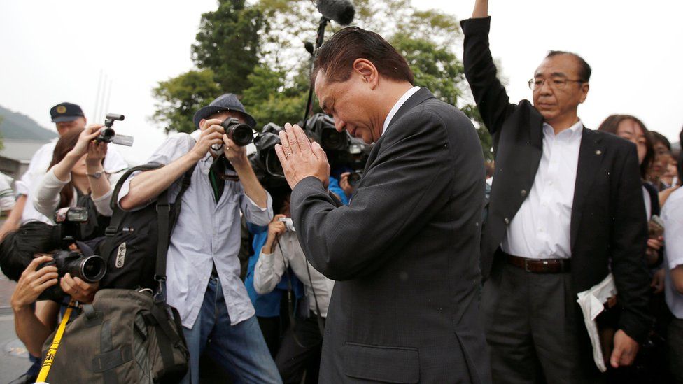 Governor of Japan"s Kanagawa prefecture Yuji Kuroiwa (C) prays to mourn victims as he visits a facility for the disabled, where a deadly attack by a knife-wielding man took place, in Sagamihara, Kanagawa prefecture