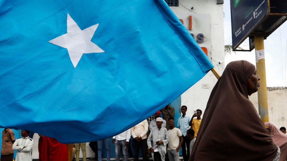 A Somali woman carries the Somali flag during a protest march.
