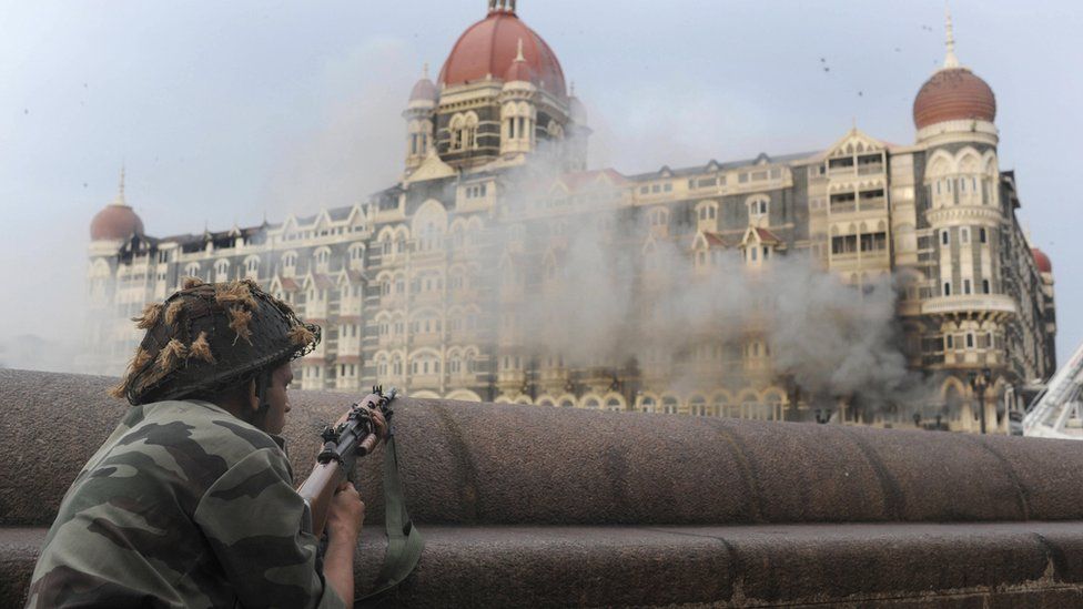 This photograph taken on November 29, 2008 shows an Indian soldier aiming his weapon towards The Taj Mahal Hotel in Mumbai.