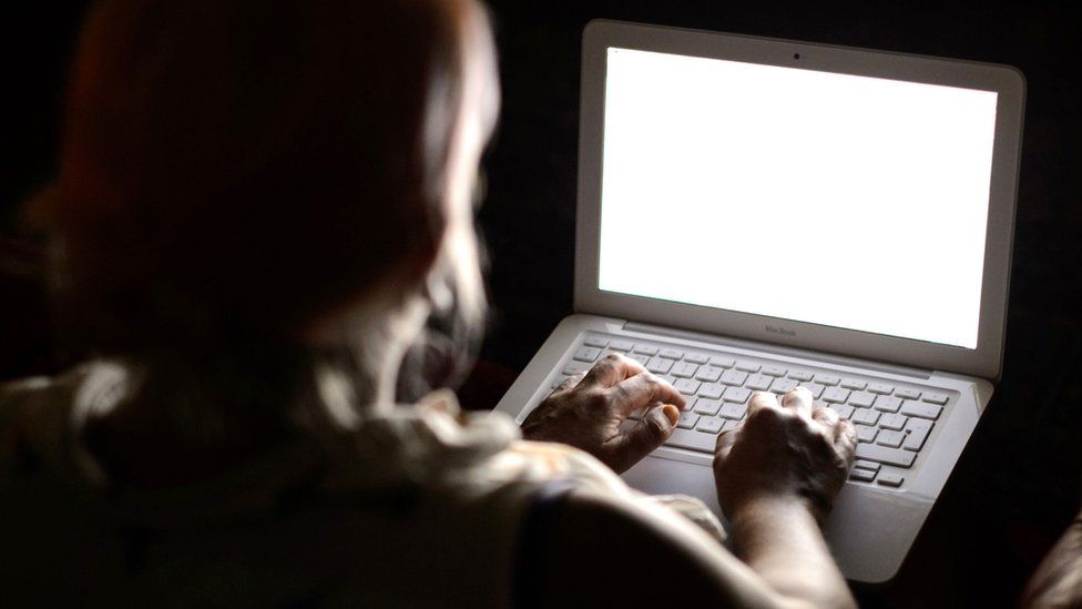 Person using a laptop in the dark