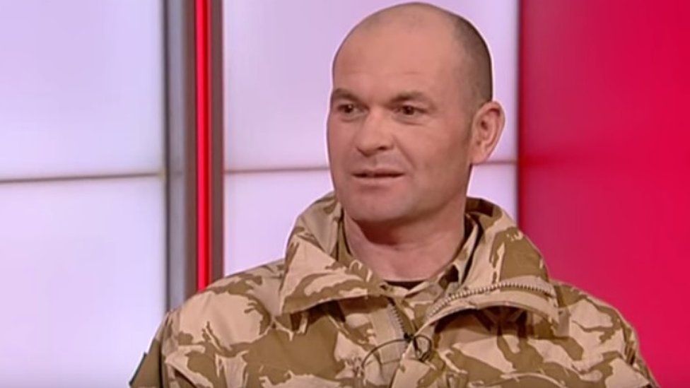 Spencer Beynon in a TV studio wearing army clothes