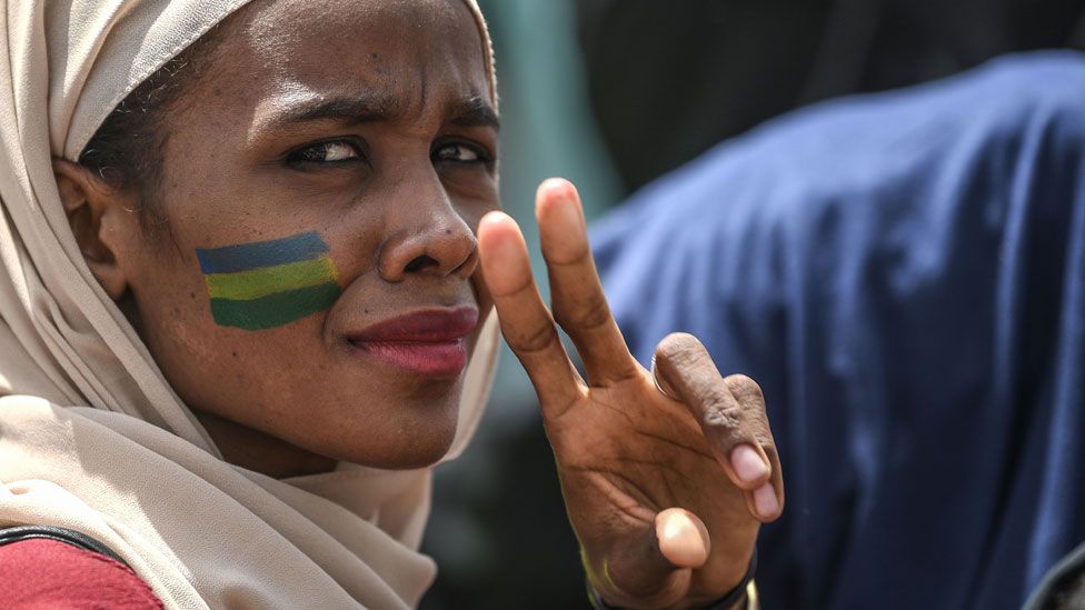 A Sudanese protester flashes the victory sign during a rally outside the army complex in Sudan"s capital Khartoum on April 18, 2019.