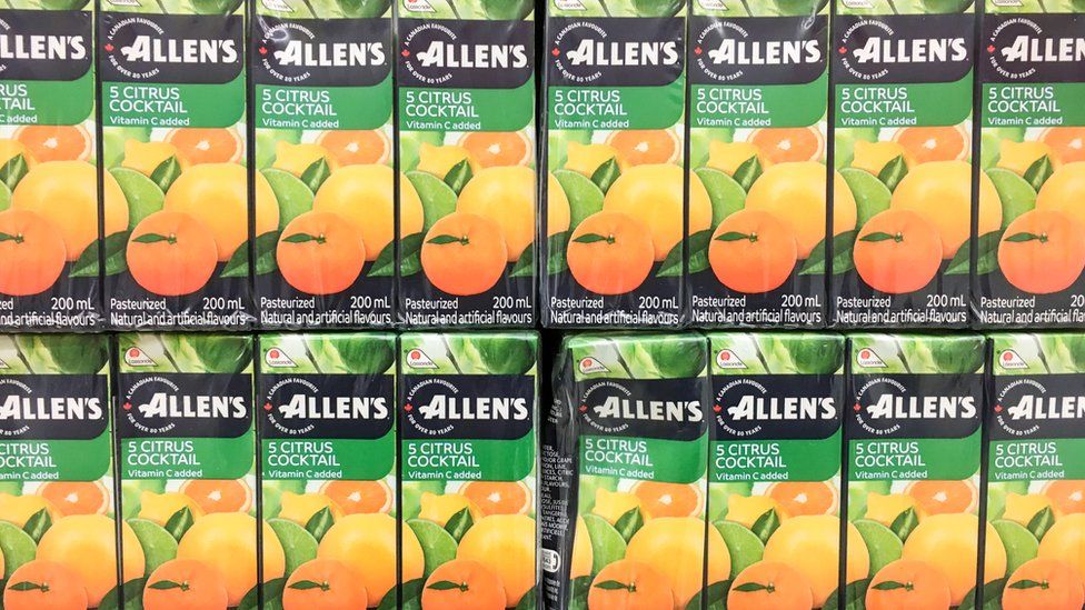 Tetra packs of Allen's five citrus cocktail with vitamin C stacked neatly in rows.