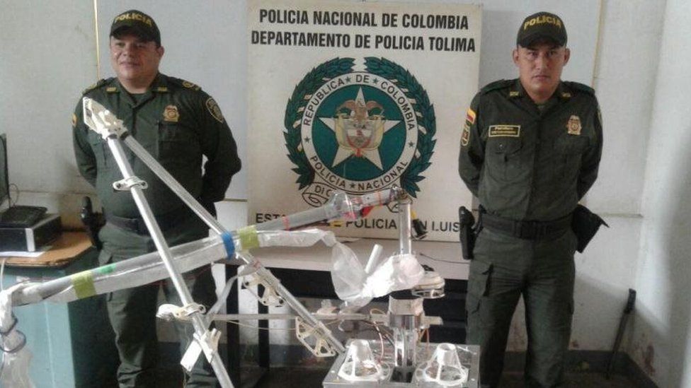 Colombian police officers pose with the object which crashed in Tolima province