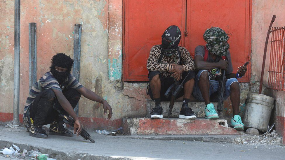 Gang members sit together after former police officer Jimmy "Barbecue" Cherizier, and leader of an alliance of armed groups, addressed the media, in Port-au-Prince, Haiti, March 11, 2024.