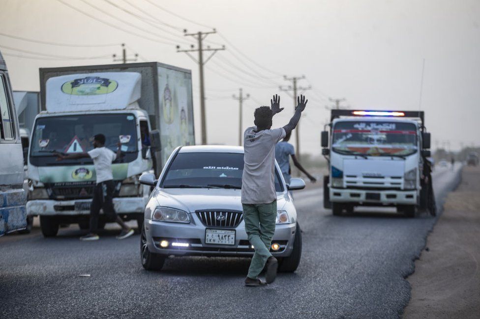 A Sudanese man goes infront of cars to invite passengers to join an iftar dinner in Khartoum, Sudan - Saturday 25 March 2023