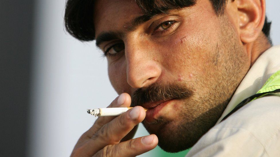 A Pakistani cosntruction worker smokes a cigarette in Dubai