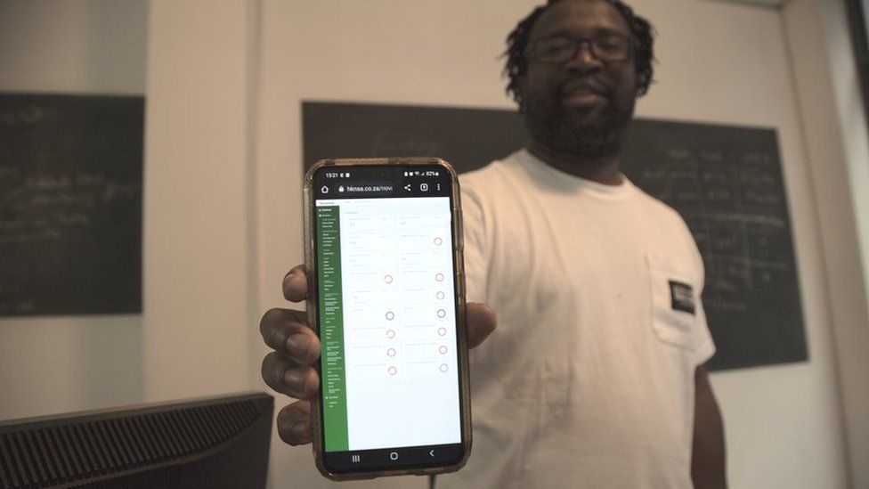 Stanford Mogotsi showing the app his firm designed for Heineken staff
