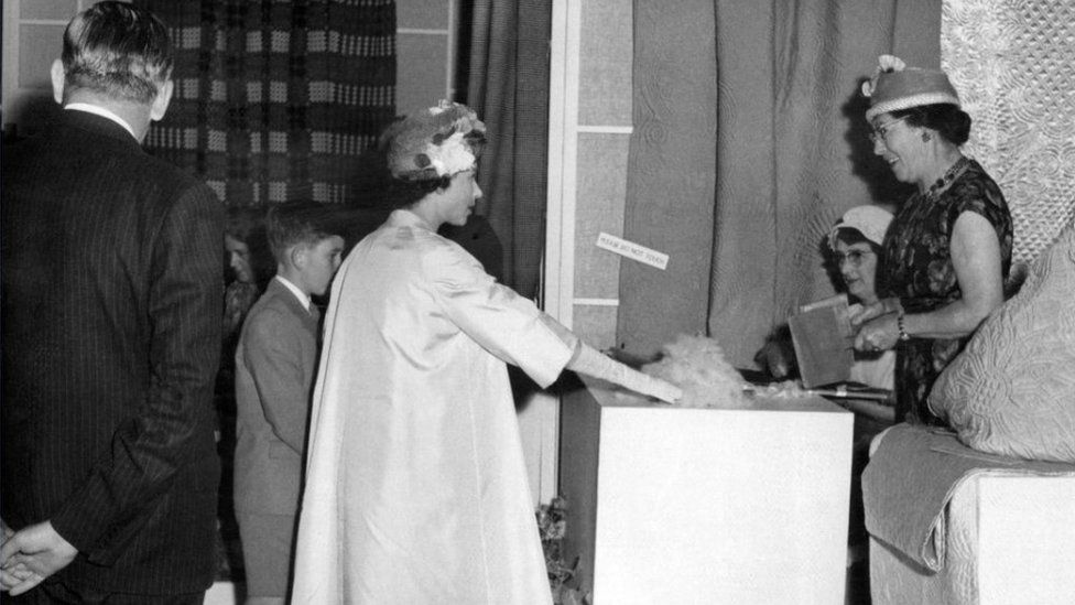 The Queen takes an interest in some of the quilts exhibited at the Arts and Crafts Section of the Eisteddfod. Cardiff, Wales, 6th August 1960