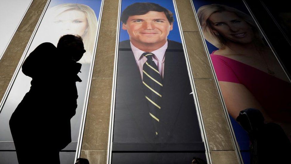 Tucker Carlson seen on a billboard at Fox Corporation headquarters in Manhattan