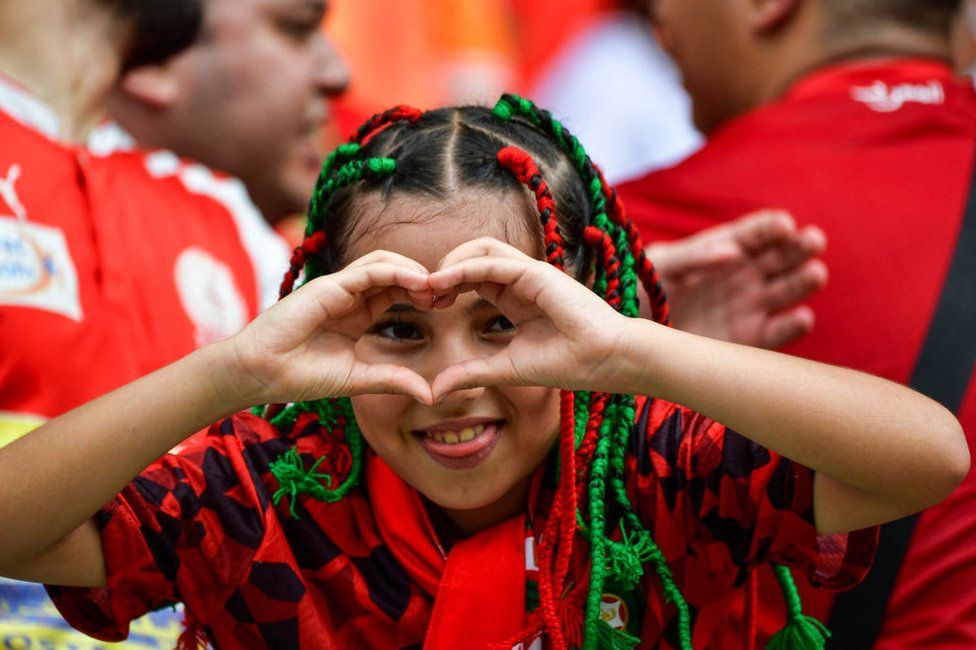 A young Morocco supporter gestures to the camera.