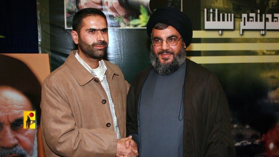 Handout image from Hezbollah Media Office showing Wissam Tawil (L), a commander killed in a suspected Israeli strike in southern Lebanon on 8 January 2024, shaking hands with leader Hassan Nasrallah (R)