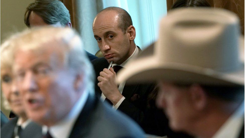 President Donald Trump speaks as Senior Advisor to the President Stephen Miller (C) listens during a round-table discussion on border security and safe communities with State, local, and community leaders in the Cabinet Room of the White House on January 11, 2019