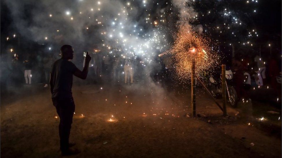 A man records fireworks with his mobile phone during the "Adoraciones al Nino Dios" celebrations in Quinamayo, department of Valle del Cauca, Colombia, on February 18, 2018.