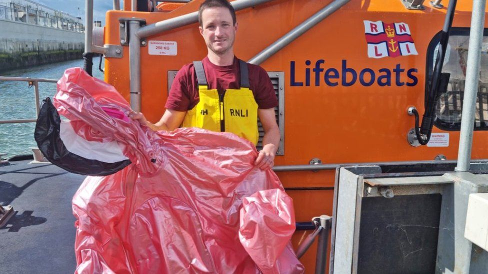 A member of the Lowestoft RNLI crew shows off the inflatable found out at sea