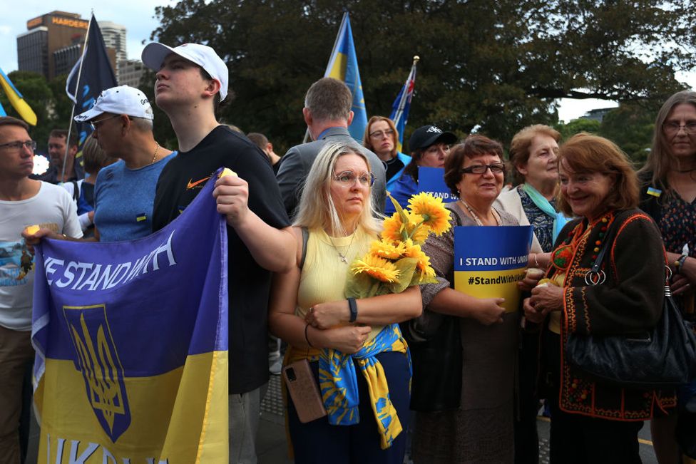 Паруса Сиднейского оперного театра подсвечивают цветами украинского флага в ознаменование годовщины начала вторжения России в Украину в Сиднее, Австралия, 24 февраля 2023 года.