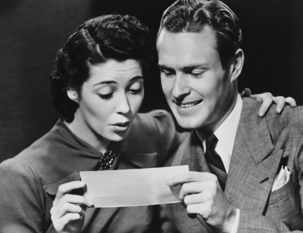 Young couple reading telegram in studio. File photo