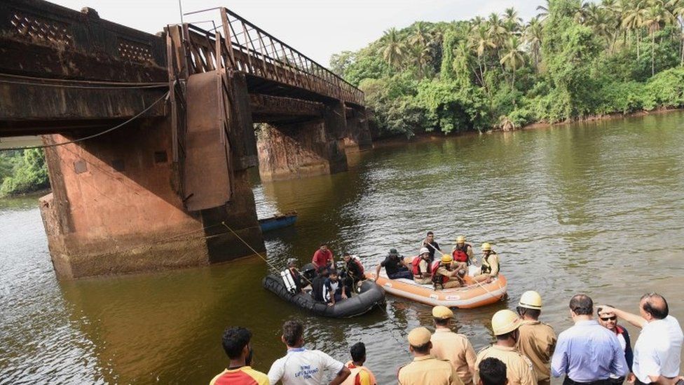 Indian rescue workers and navy divers look for survivors near the foot bridge collapse site in Curchorem, South Goa on May 19, 2017