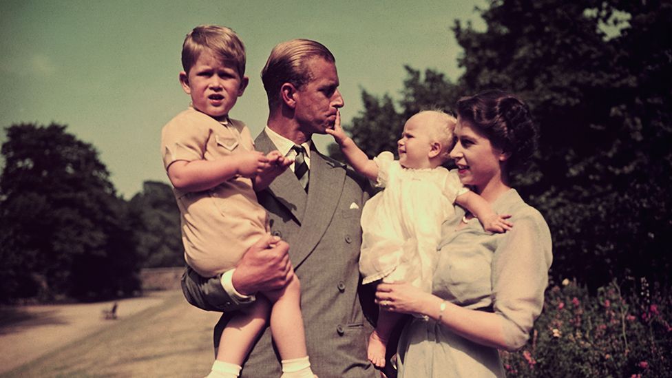 Princess Anne in the arms of Princess Elizabeth, with the Duke of Edinburgh, holding Prince Charles, in the grounds of Clarence House, London, in August 1951