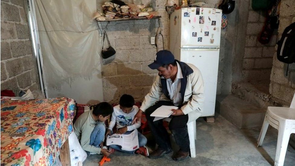 Facundo Martinez reviews school work with his children after a televised class as millions of students returned to classes virtually after schools were ordered into lockdown in March, due to the coronavirus disease (COVID-19) outbreak, in Chilcuautla, Hildalgo state, Mexico August 24, 2020.