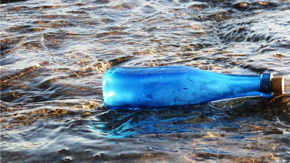 Blue bottle floating in the sea